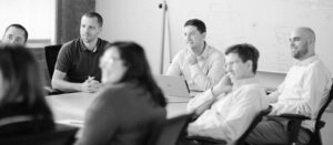 black and white photo of business team sitting around table