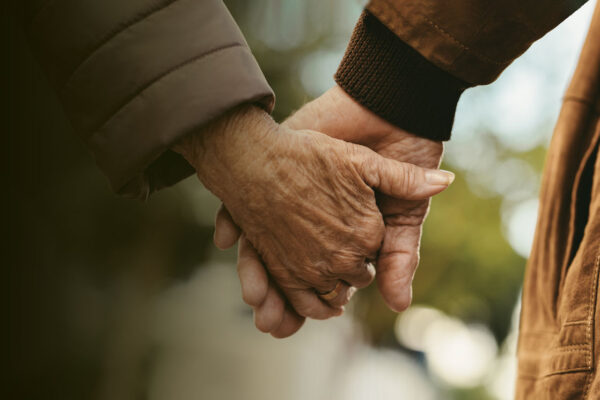 older people holding hands