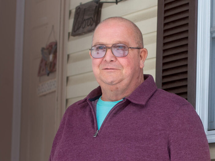 Person in purple sweater looking at camera