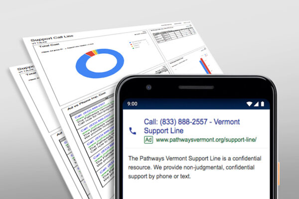 Phone showing Vermont Support Line, paper with graphs and text in background