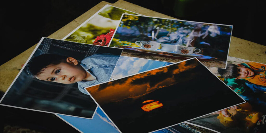 printed photographs in a pile on a table