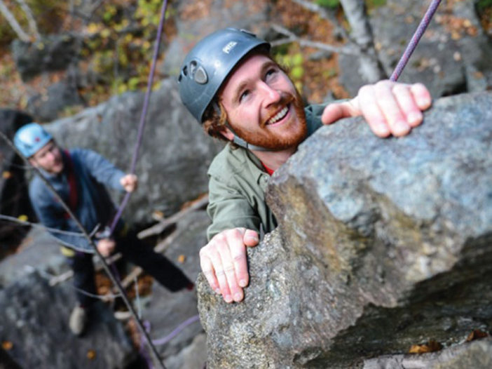 Two people climbing rocks
