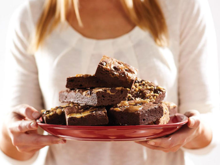A person holding a plate of brownies